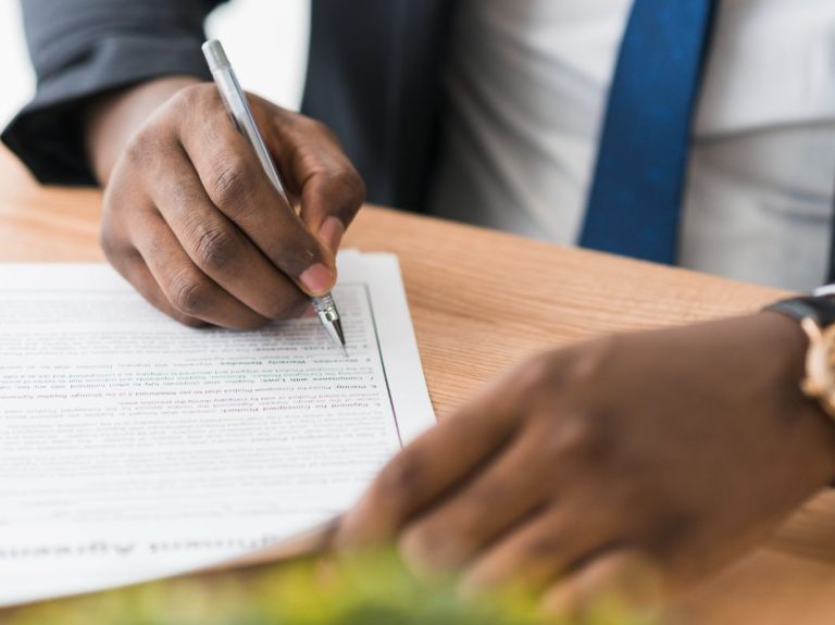 crop-ethnic-businessman-signing-papers-1